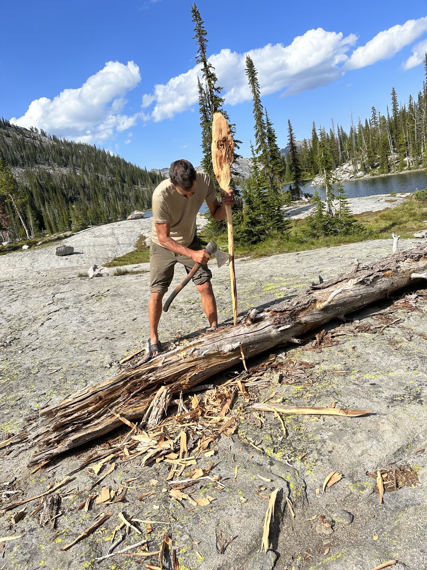 Jordan splitting a log with a Taiga axe on a granite slab